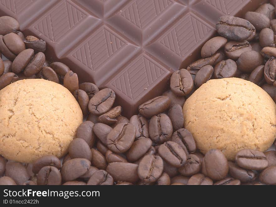 Chocolate and cookies on the coffee beans background. Selective focus. Chocolate and cookies on the coffee beans background. Selective focus