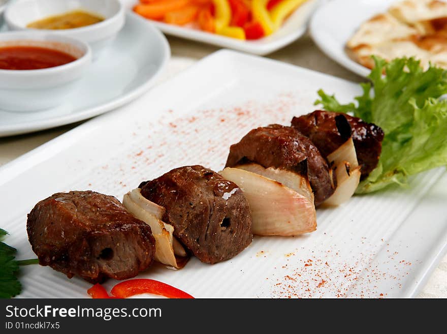 Appetizing Shish Kebab With Tomatoes And Greens