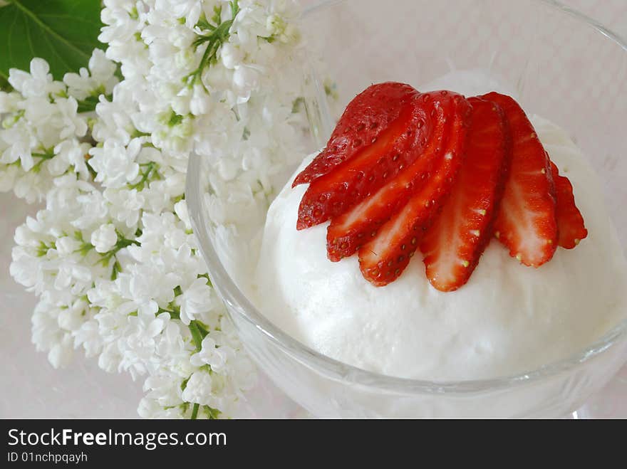 Milk frozen decorated by a strawberry and branch of white lilac