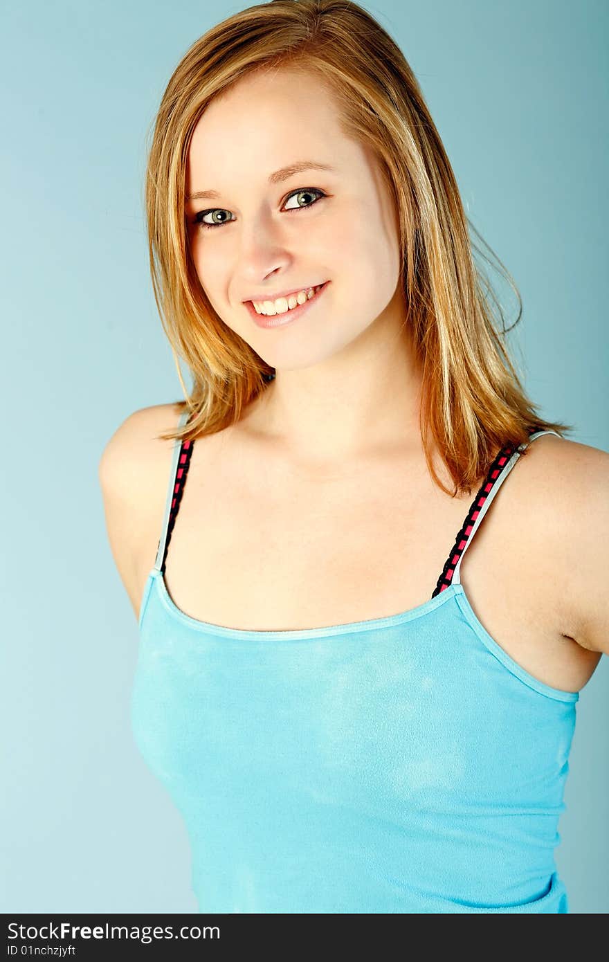 Fifteen year old cutie wearing blue tank top set against blue backdrop. Fifteen year old cutie wearing blue tank top set against blue backdrop.