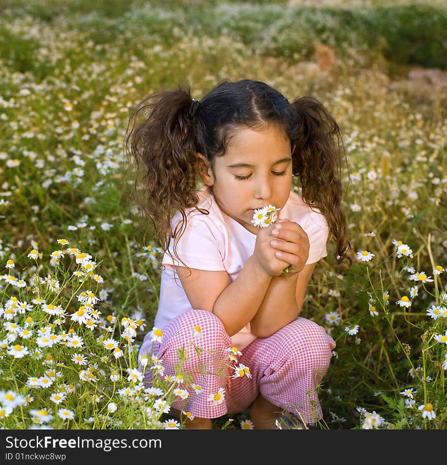 Girl holding flowers in field at sunset