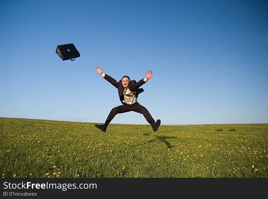 Jumping Businessman in meadow - green grass and blue sky. Jumping Businessman in meadow - green grass and blue sky