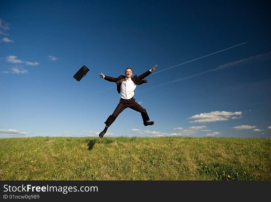 Jumping Businessman in meadow - green grass and blue sky. Jumping Businessman in meadow - green grass and blue sky