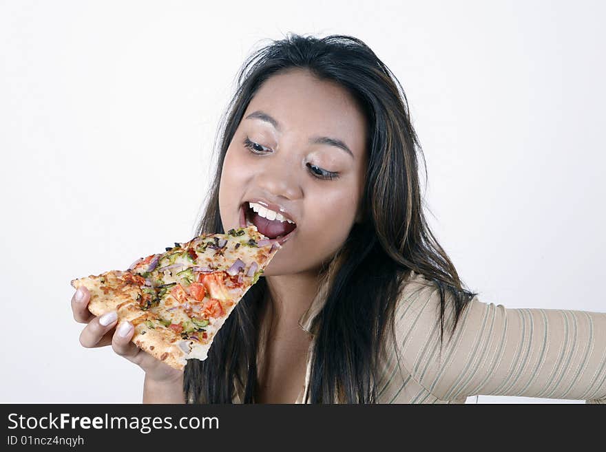 Sweet and pretty girl eating pizza slice and posing