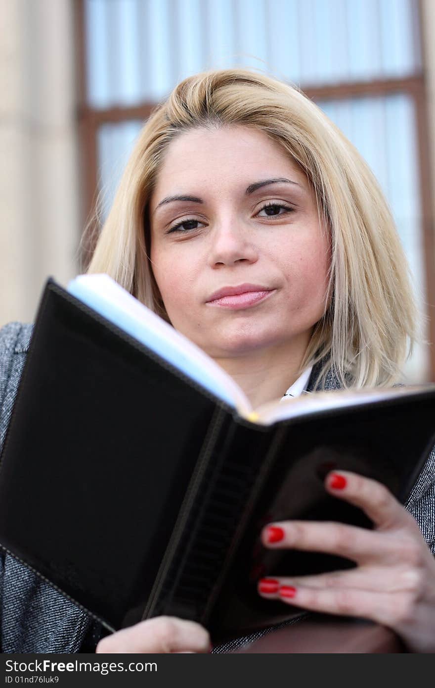 Beautiful business woman with book in hand. Beautiful business woman with book in hand