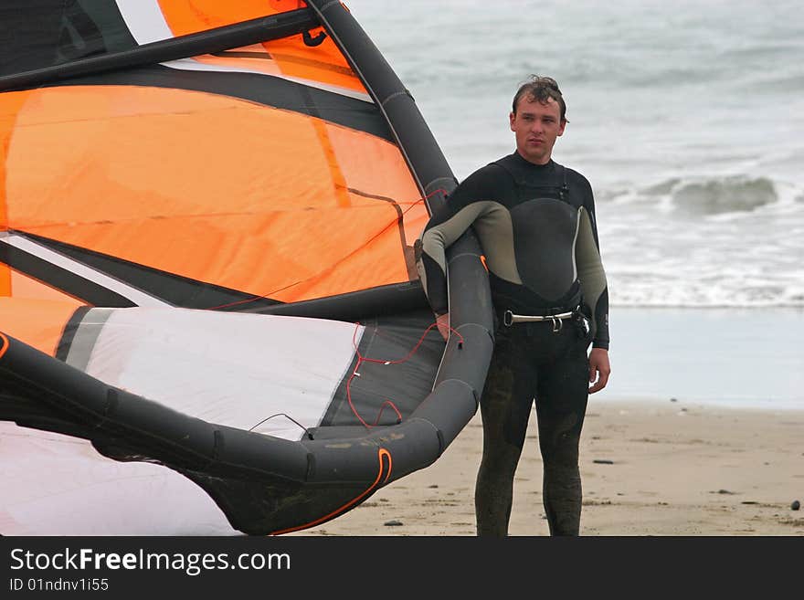 Kitesurfer holding kite on beach