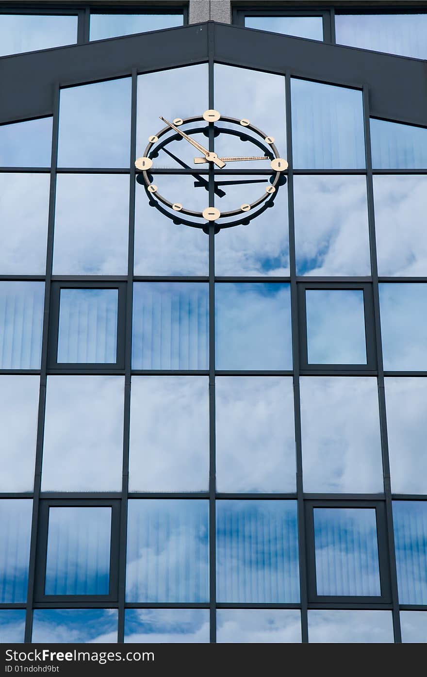 A blue glass wall with a clock on it. A blue glass wall with a clock on it