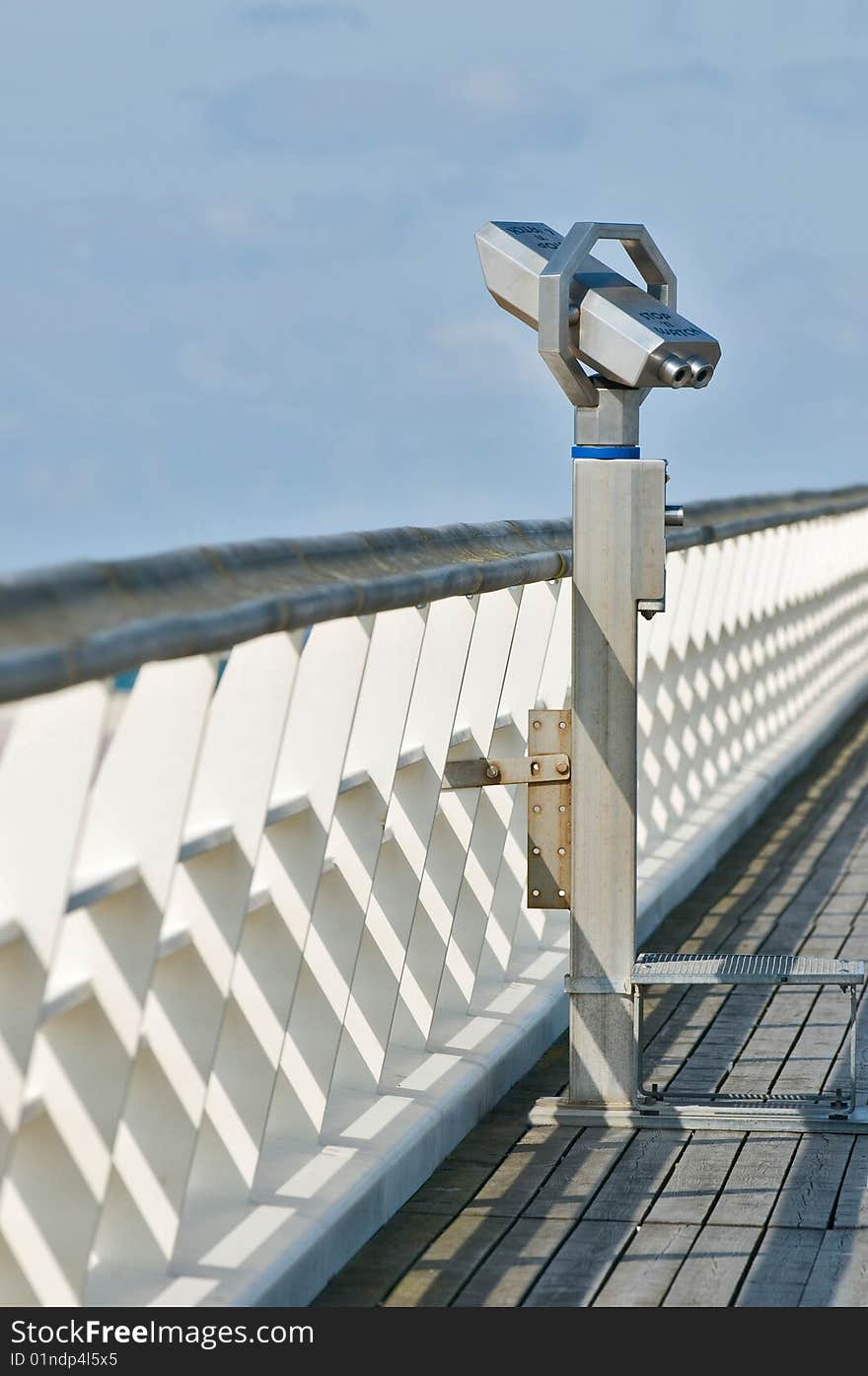 A grey binocular on a wooden gangway