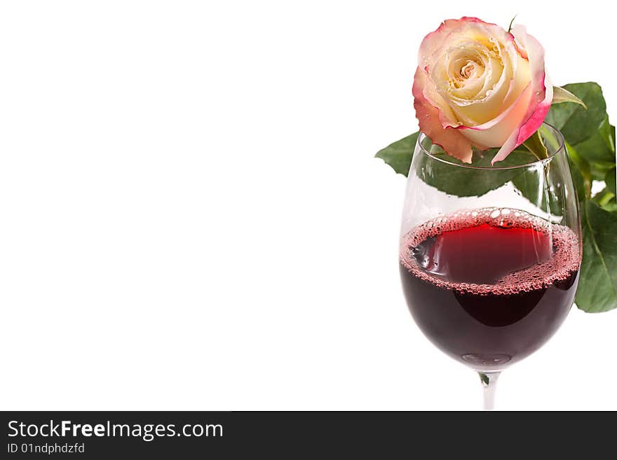 A glass of red wine with pink rose isolated on white background. A glass of red wine with pink rose isolated on white background