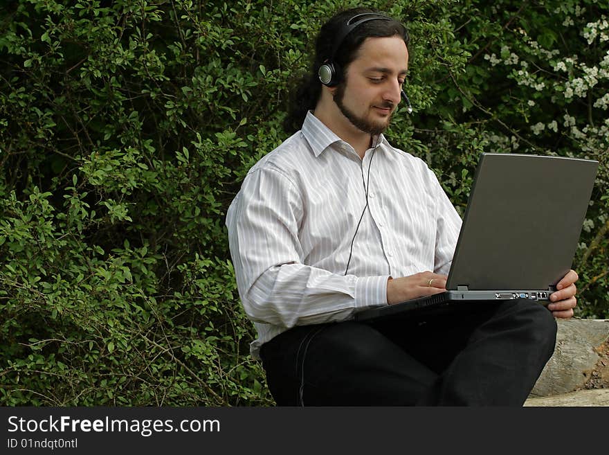 A man with headset, working outside. A man with headset, working outside