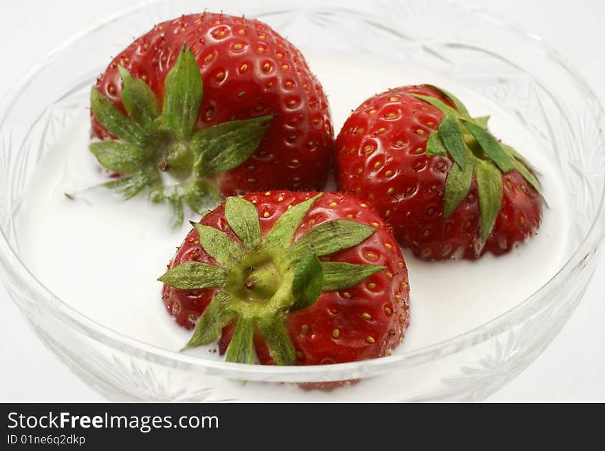 The ripe strawberry with cream, is photographed on a white background. The ripe strawberry with cream, is photographed on a white background