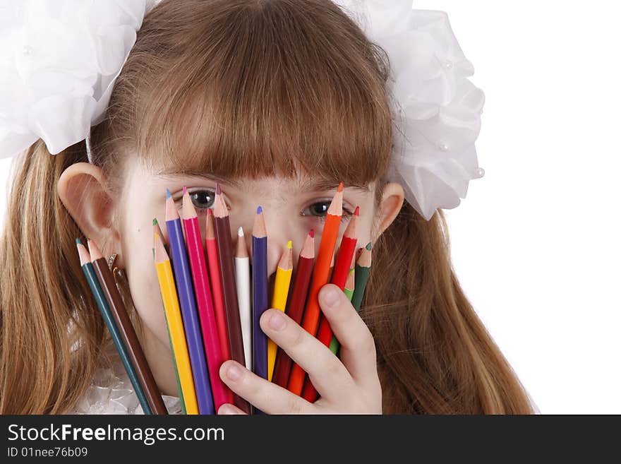 A smiling girl with color pencils in hands on a white background. Schoolgirl is holding coloured pencils. A smiling girl with color pencils in hands on a white background. Schoolgirl is holding coloured pencils.