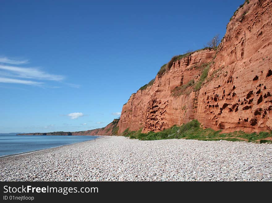 Sandstone cliffs beside shingle beach. Sandstone cliffs beside shingle beach