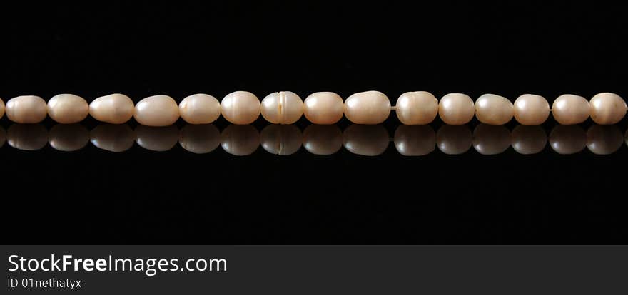 A pearl necklace on black background. A pearl necklace on black background.