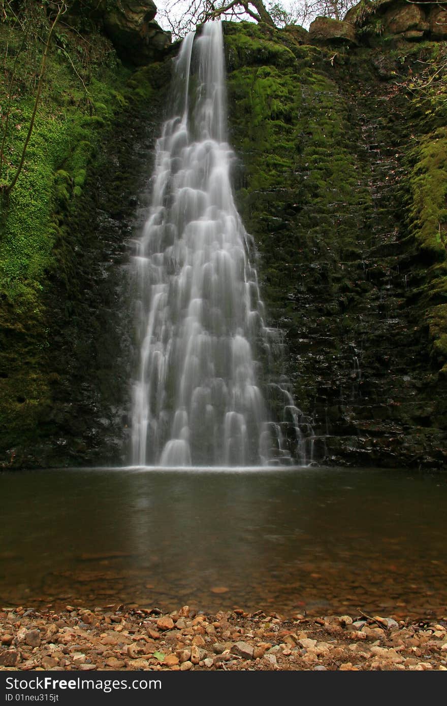 A waterfall over rocks into a deep pool