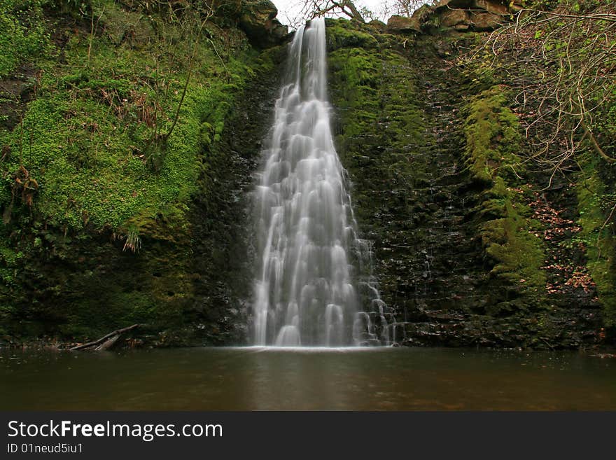 A waterfall over rocks into a deep pool