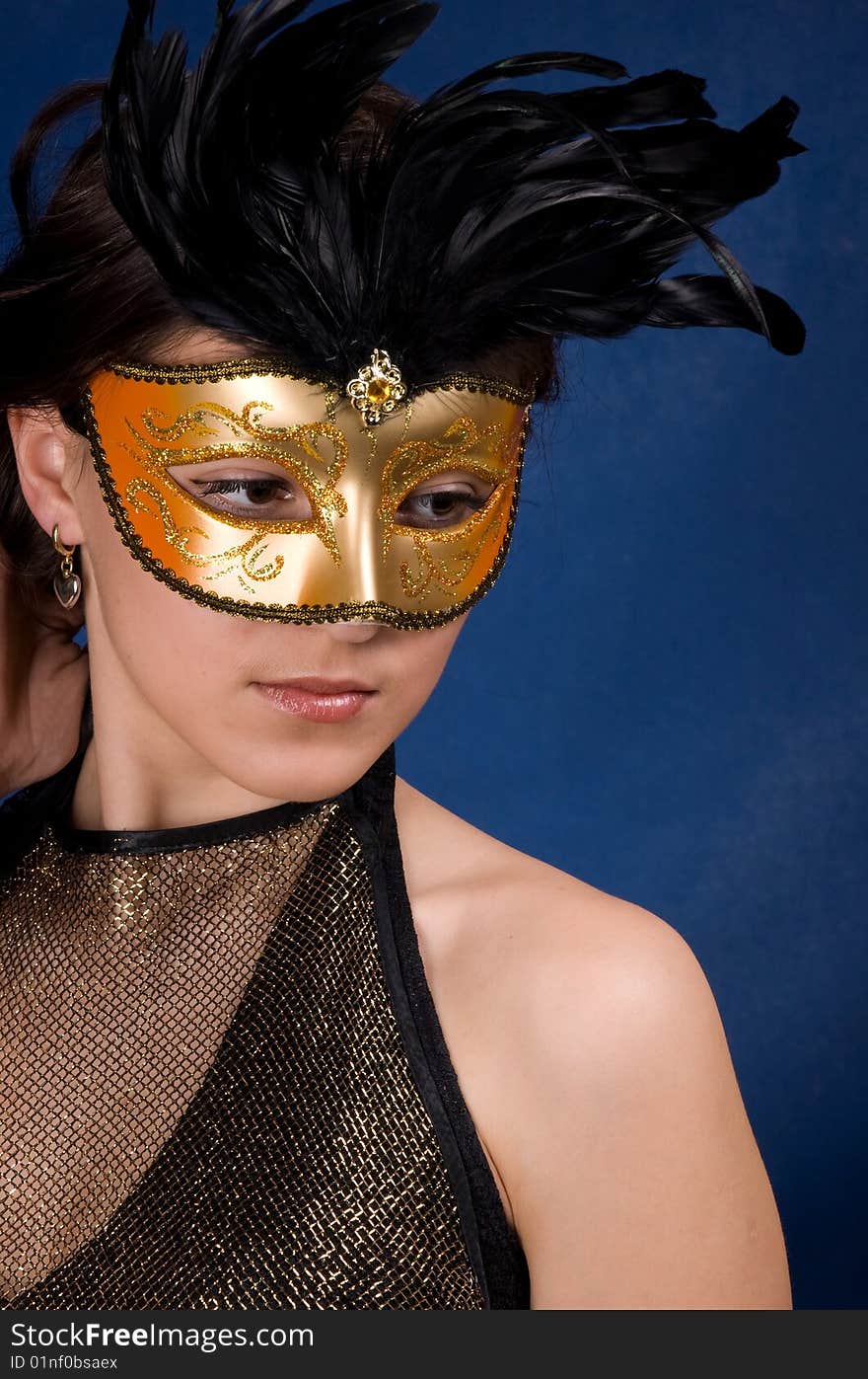 The young girl in a mask, is photographed on a dark blue background. The young girl in a mask, is photographed on a dark blue background