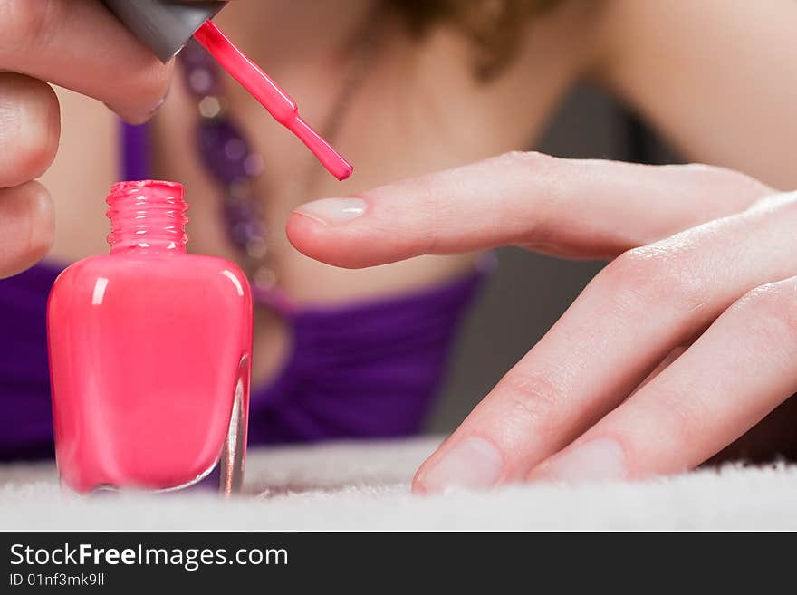 Woman applying red nail polish