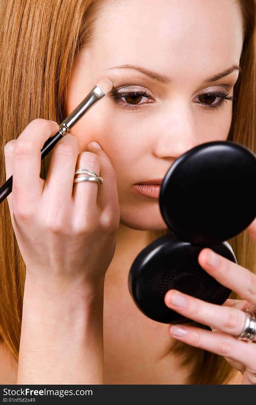 Nice caucasian model applying makeup with brush. Nice caucasian model applying makeup with brush