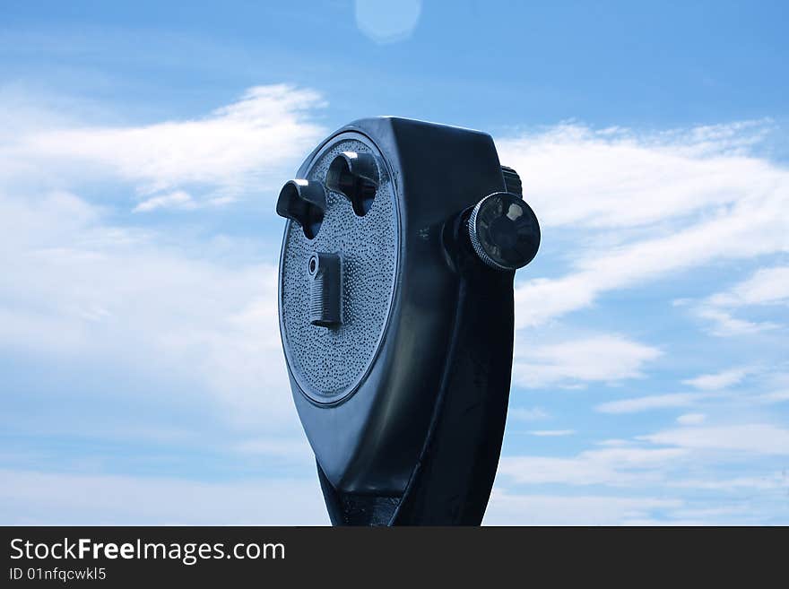 A coin operated viewfinder with clouds in background. A coin operated viewfinder with clouds in background