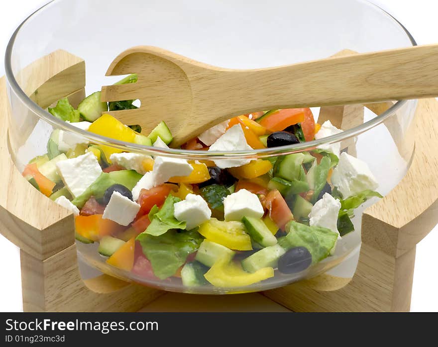 Bowl with vegetable salad and a wooden spoon