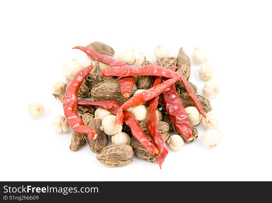 Dried red pepper and cardamom on a white background