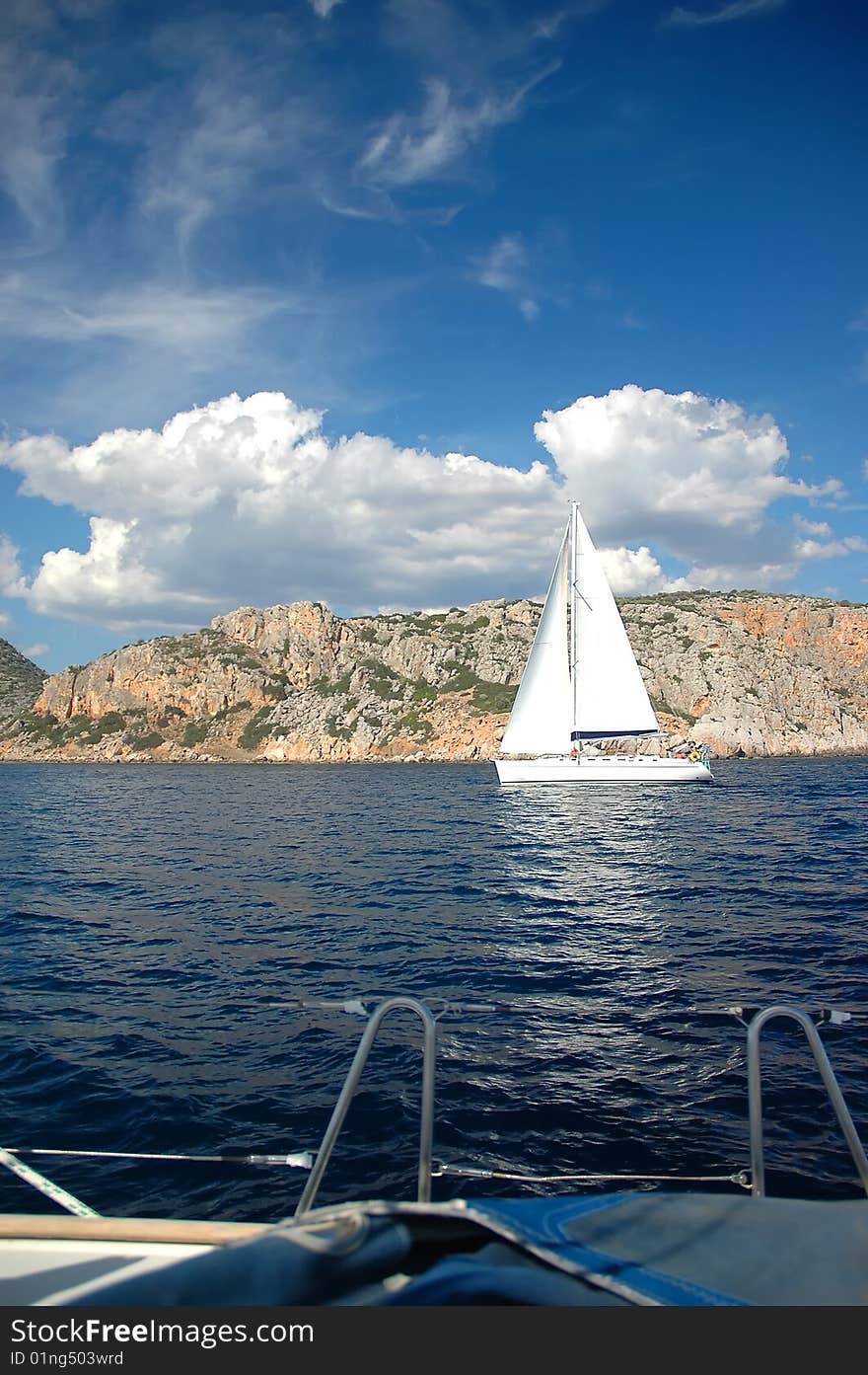 White yacht sail near shore in the sea