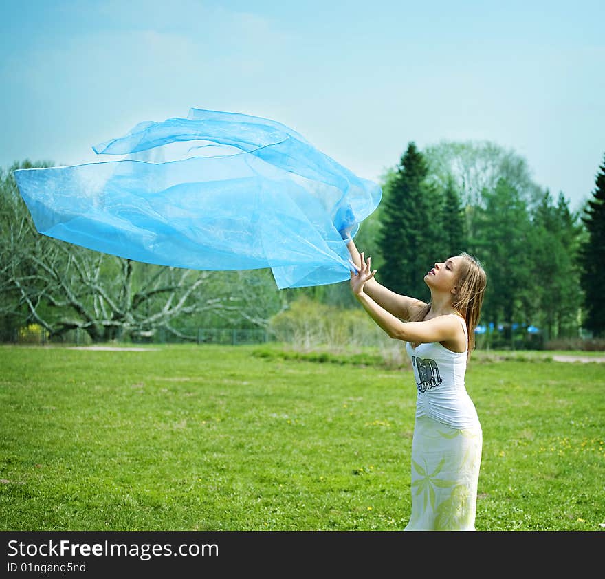 Woman dancing on the park with a blue sarong