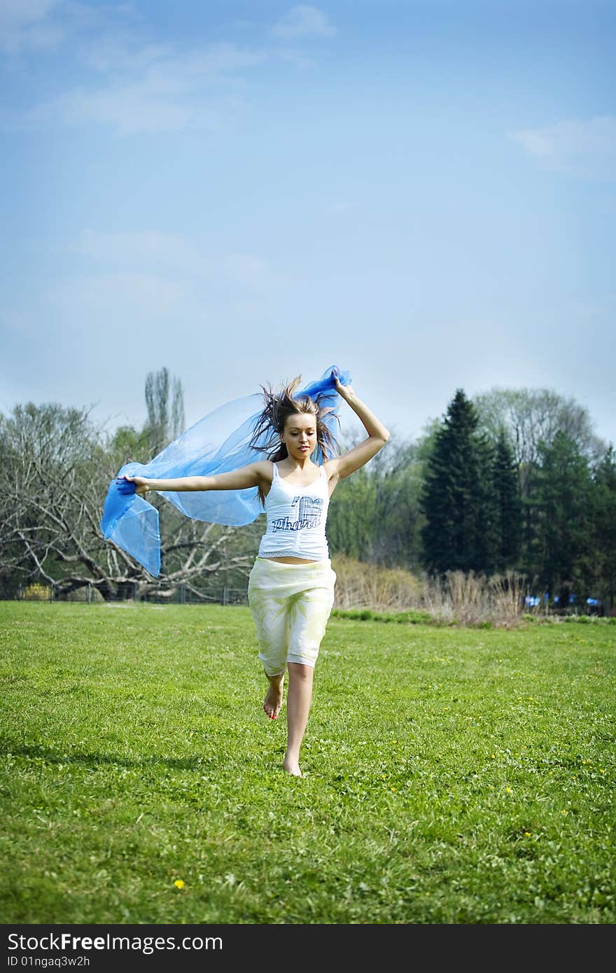 Woman dancing on the park with a blue sarong