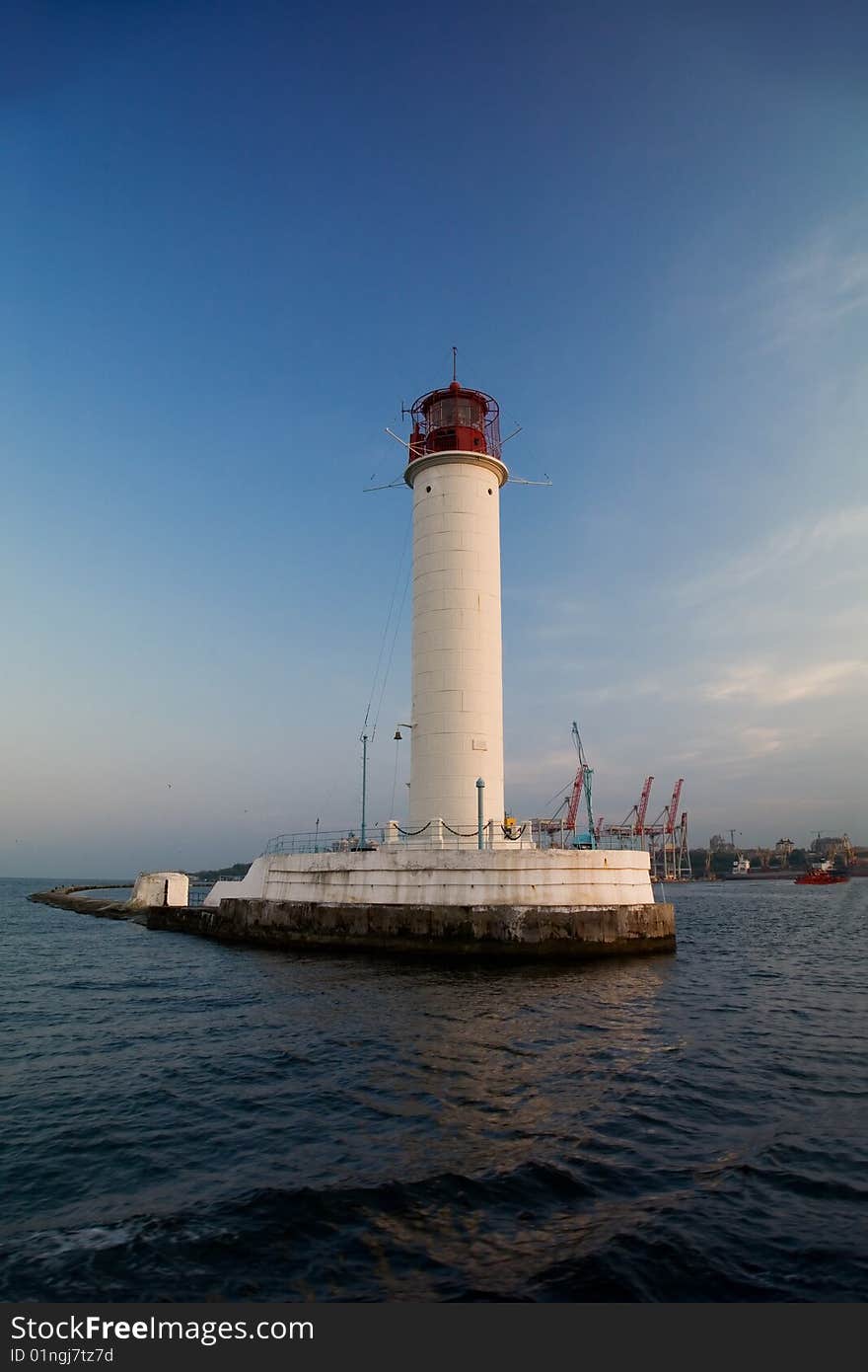 Lighthouse, industrial docks on background