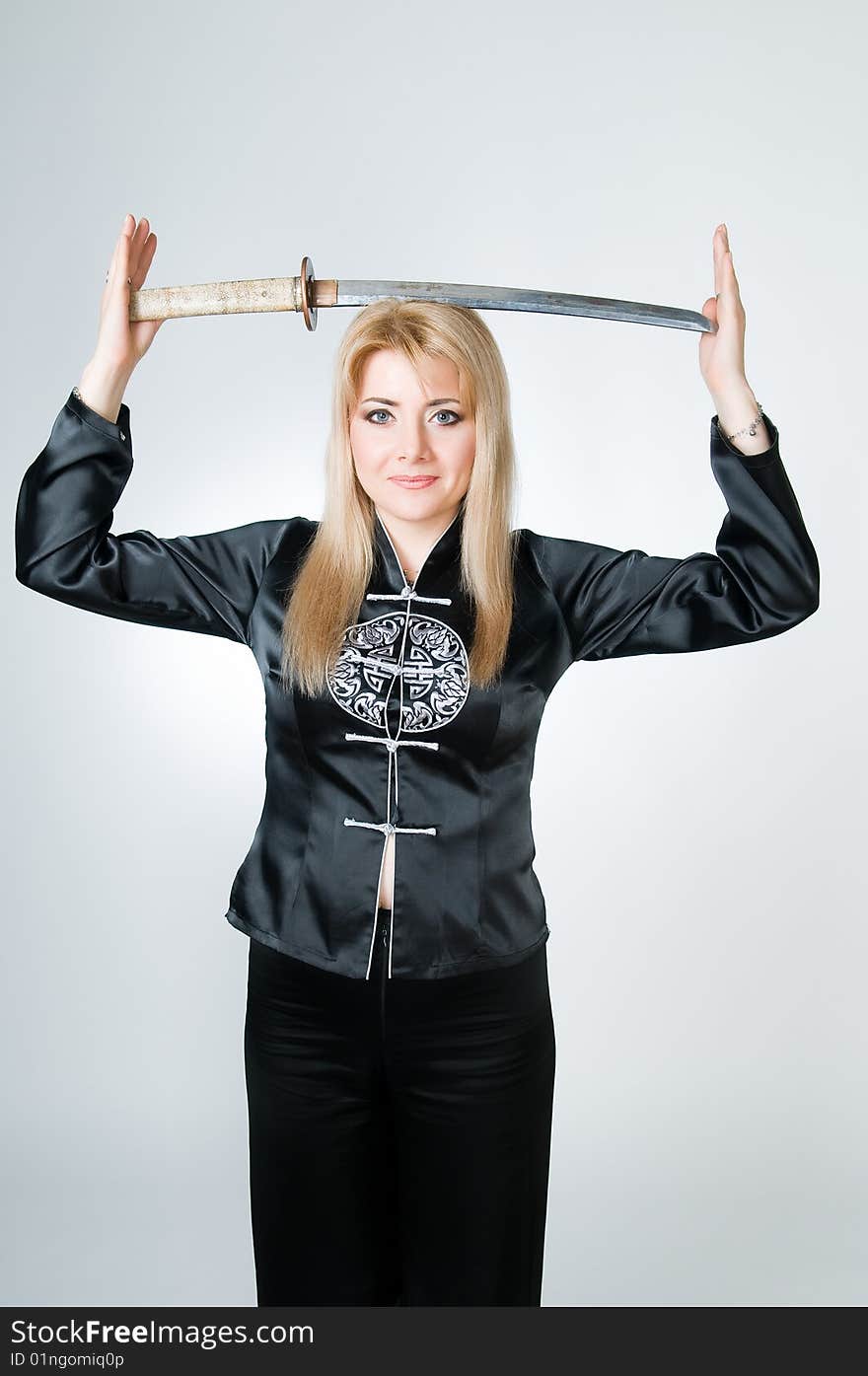 Beautiful woman in black kimono with katana, studio shot