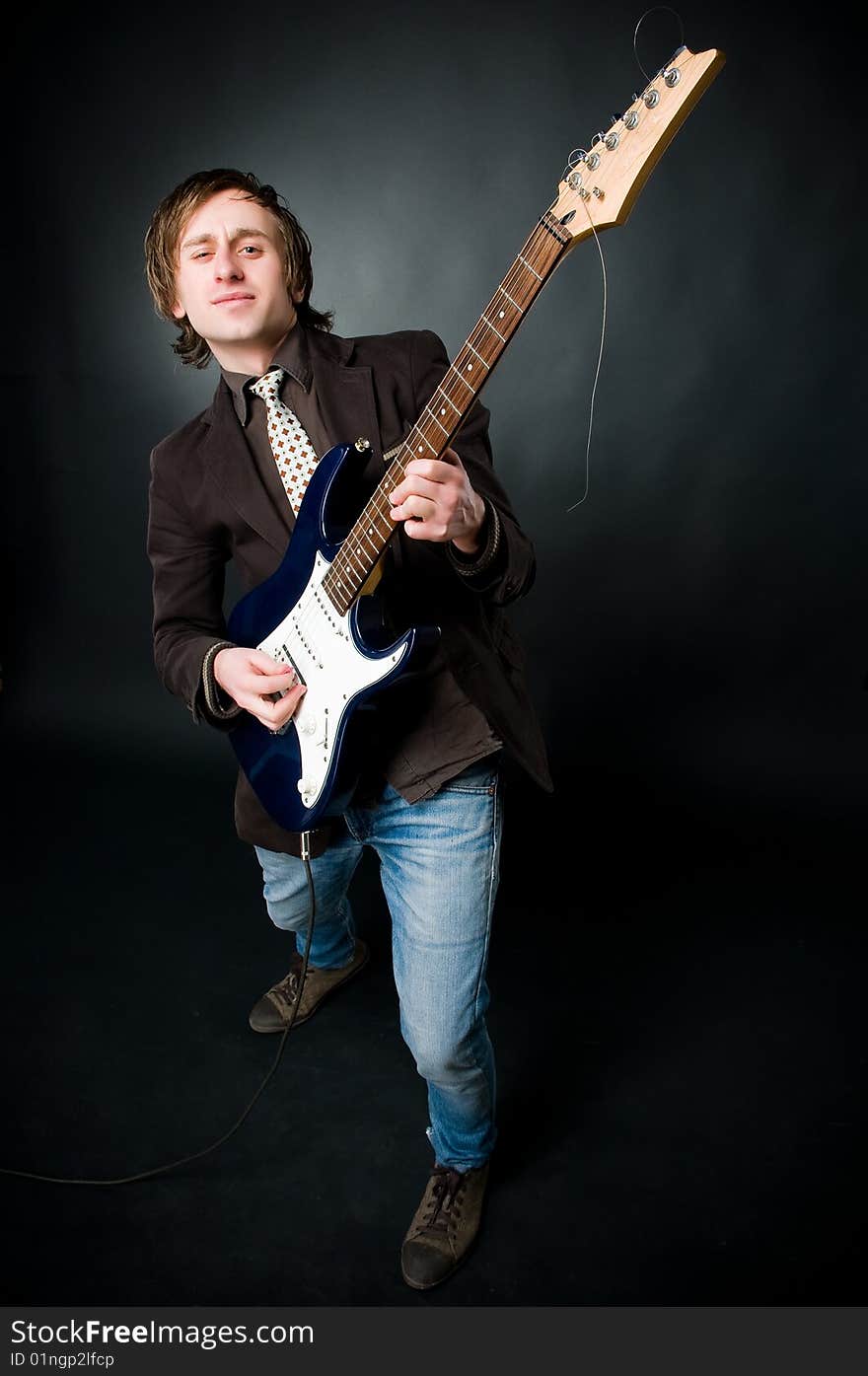 Man playing electro guitar, studio shot