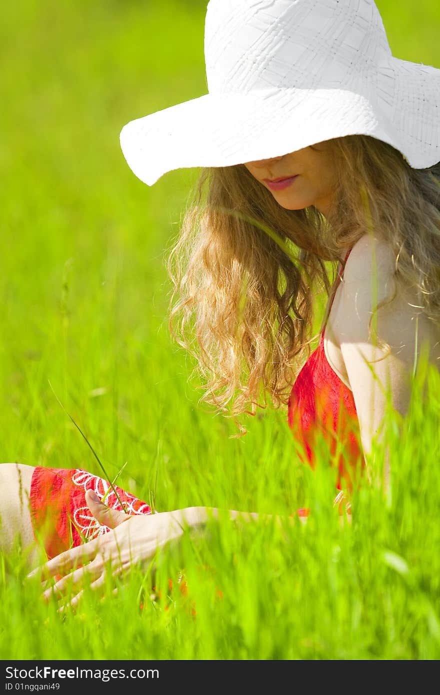 beautiful woman sitting on the grass. beautiful woman sitting on the grass