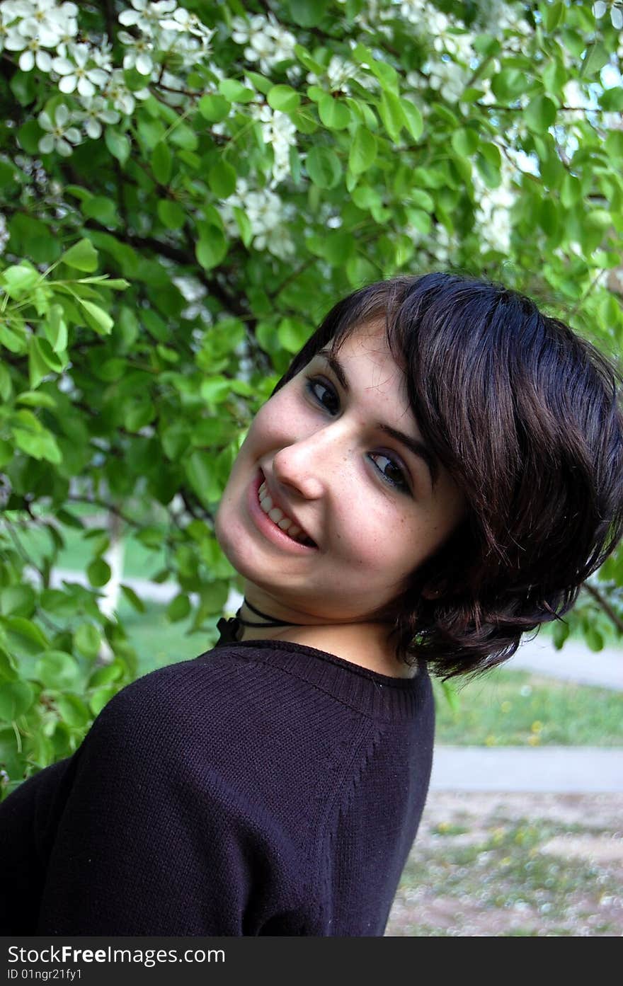 Portrait of young brunette in the spring garden. Portrait of young brunette in the spring garden