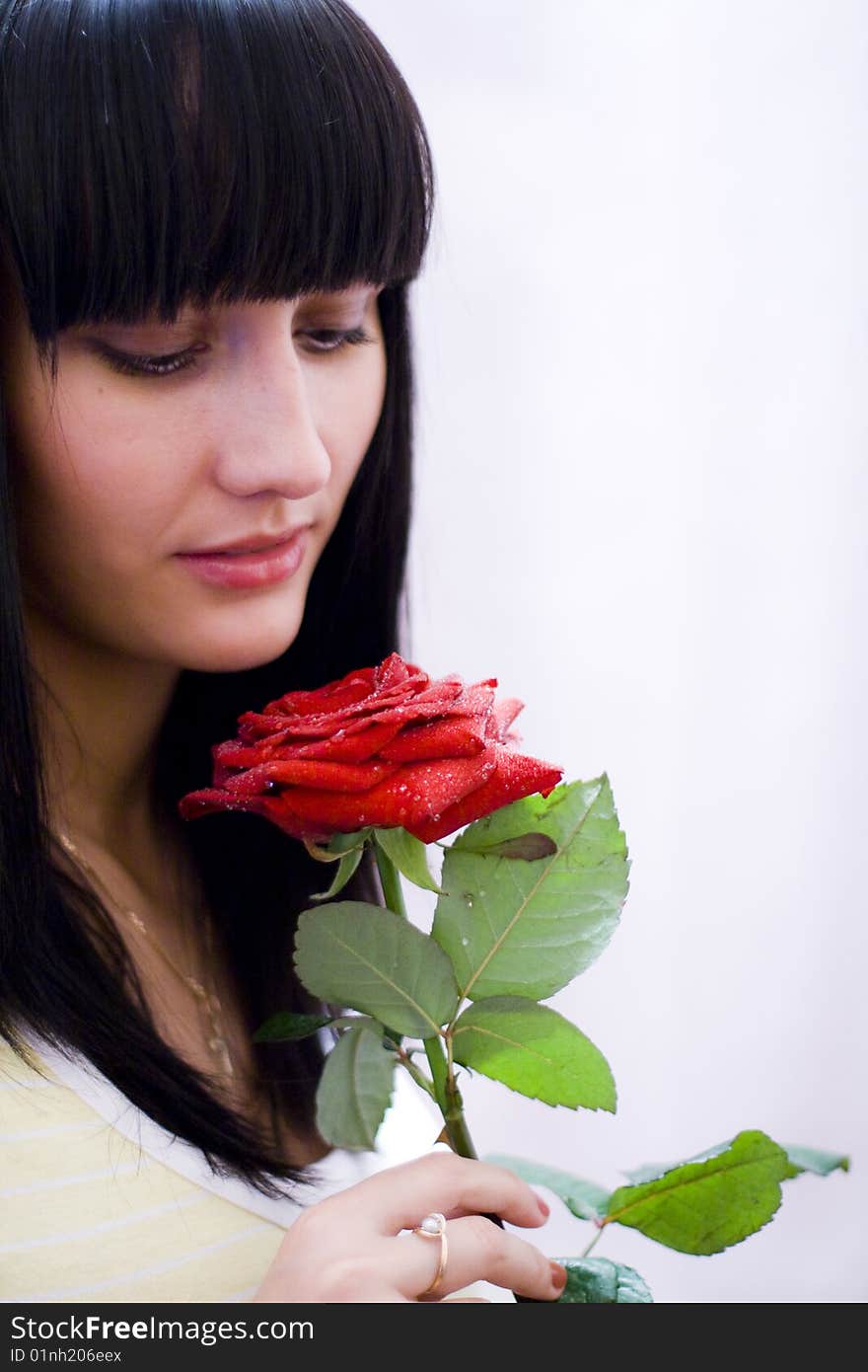 Girl sniffing beautiful flower - red rose. Girl sniffing beautiful flower - red rose