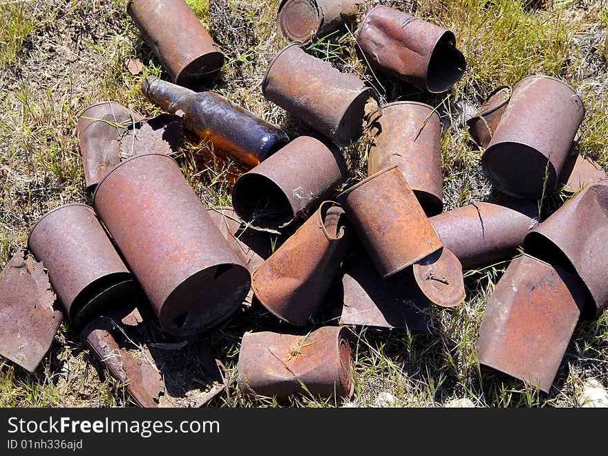 Pile of old rusted tin cans out in grass. Pile of old rusted tin cans out in grass