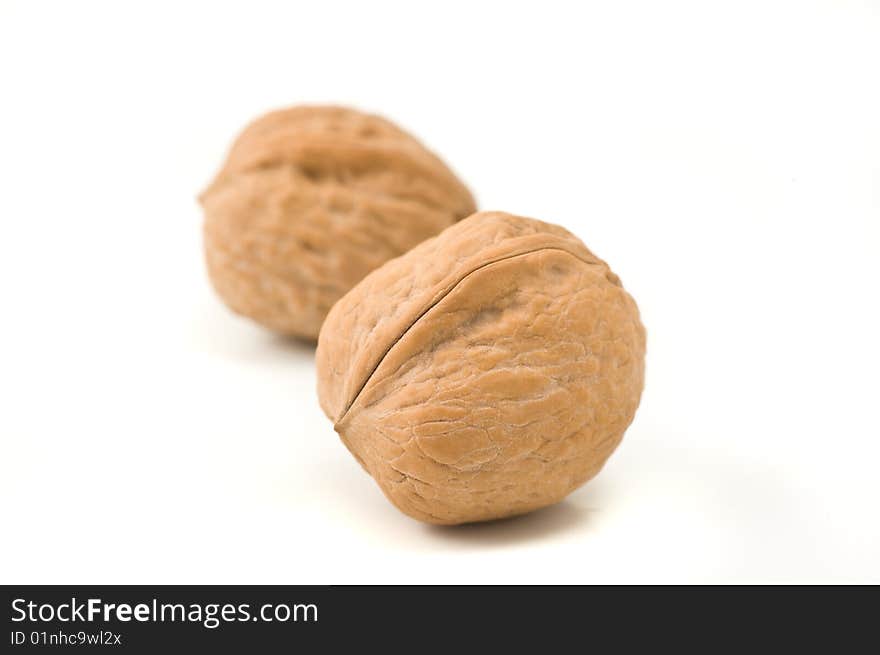 Two walnuts on white background, close up.