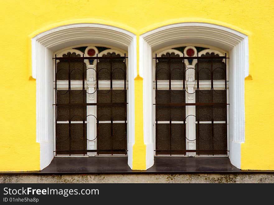 Two windows on yellow facade