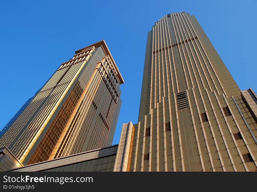 Golden Commercial Buildings tilting to blue sky. Golden Commercial Buildings tilting to blue sky