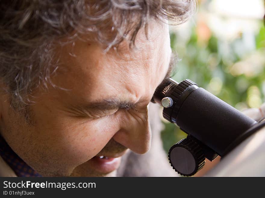 Scientist observing through his microscope. Scientist observing through his microscope