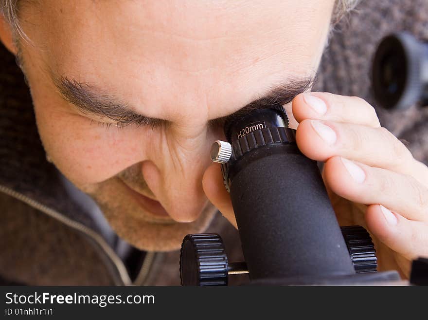 Scientist observing through his microscope. Scientist observing through his microscope