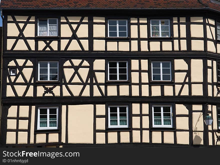 Half-timbered houses or Tudor-style houses, widely seen in historic areas of Europe, are constructed with  wooden framework and walls filled in with plaster or masonry. This one is seen in the Petite Venice area of Colmar, France.