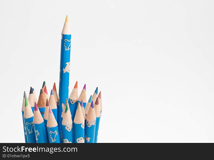 Stack of wooden crayon inside a tube case with one standing out. Stack of wooden crayon inside a tube case with one standing out