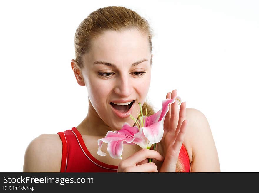 A nice blond girl in red posing with a pink lily near her face on a white background. A nice blond girl in red posing with a pink lily near her face on a white background