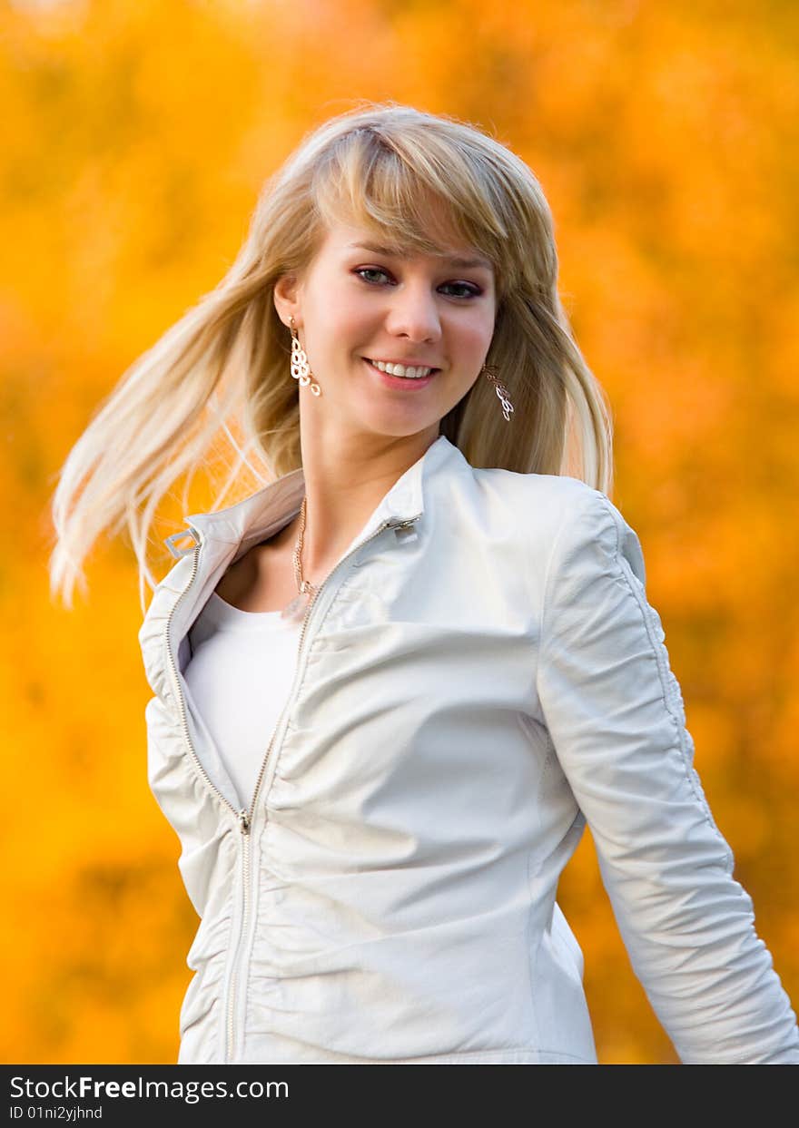 Pretty girl in white jacket on autumn park background - shallow DOF