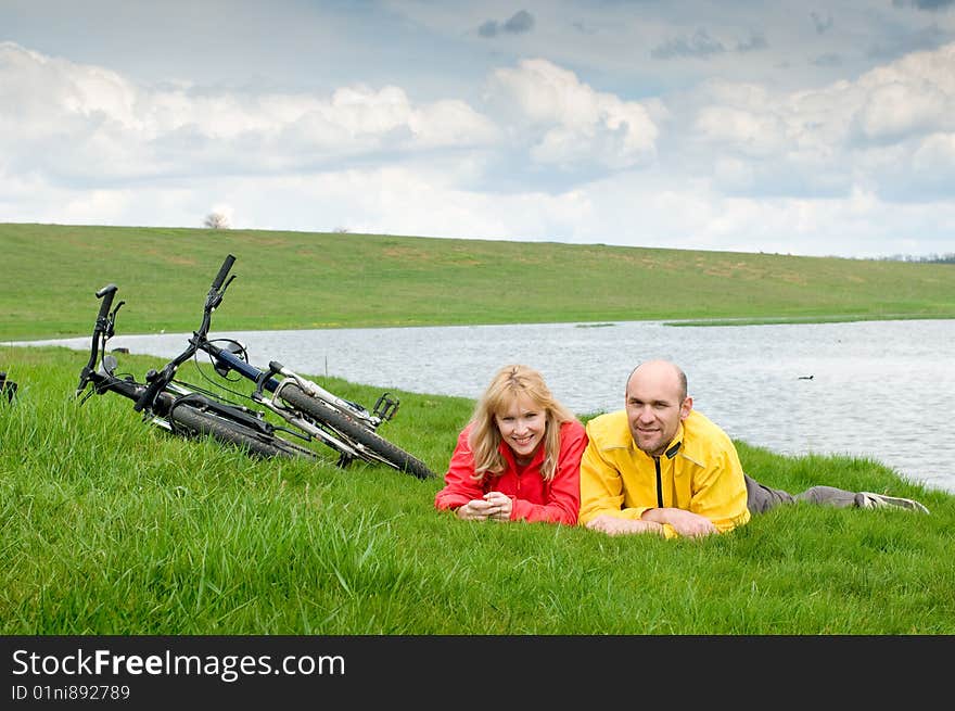 Two cyclists on river bank