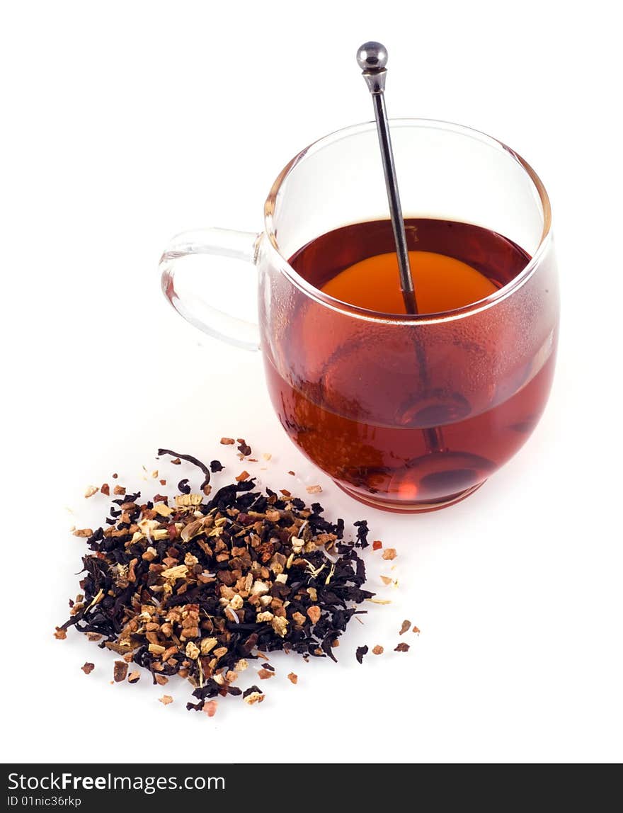 Glass of tea with some dried tea next to the glass on a white background. Glass of tea with some dried tea next to the glass on a white background.