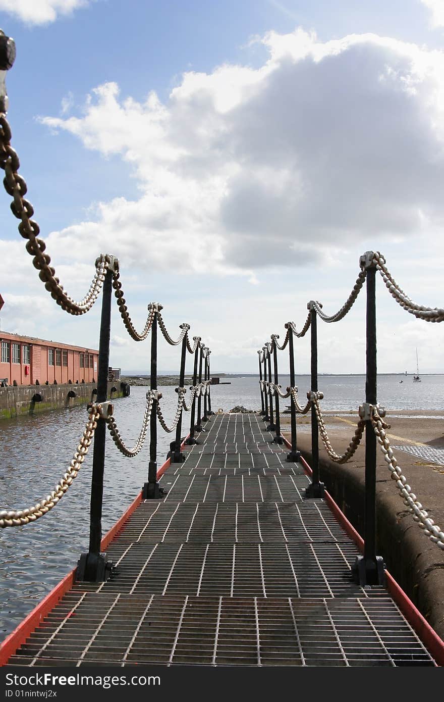 Opened dock gates with a chain fence and cloudy sky. Opened dock gates with a chain fence and cloudy sky