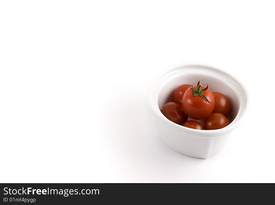 A modern minimalist white bow full of mini tomatoes, ready to be served. A modern minimalist white bow full of mini tomatoes, ready to be served