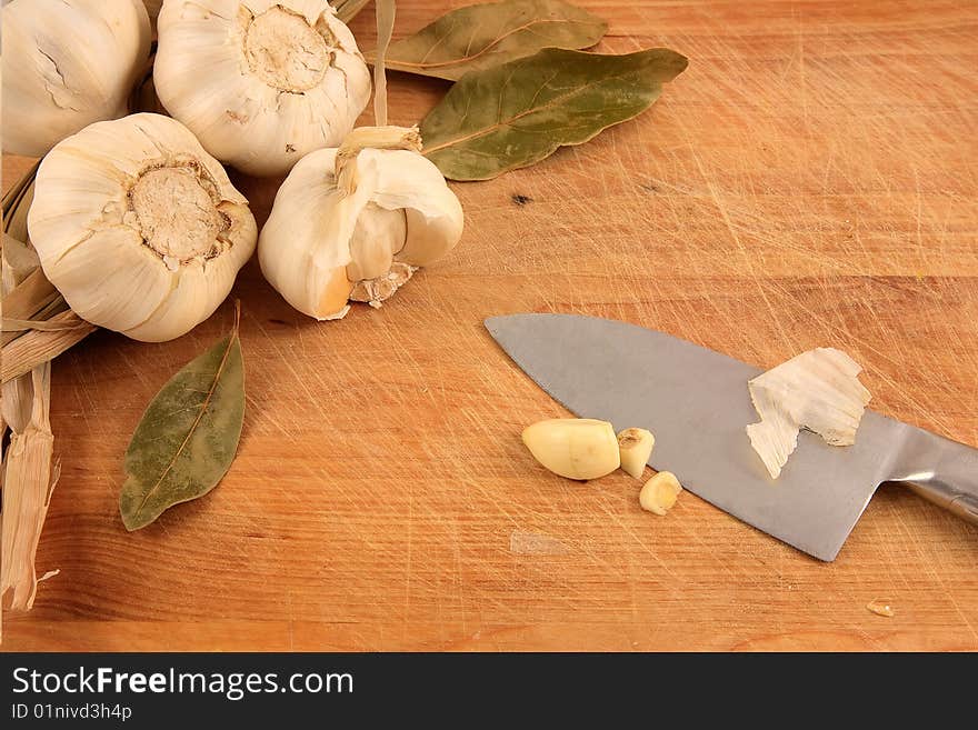 A set of Mediterranean ingredients over a wooden board ready to be chopped and used to flavour a meal. A set of Mediterranean ingredients over a wooden board ready to be chopped and used to flavour a meal